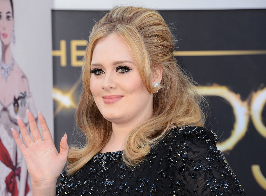 Adele, fotografiată în timp ce face cu mâna, pe covorul roșu, la Annual Academy Awards, în 2013