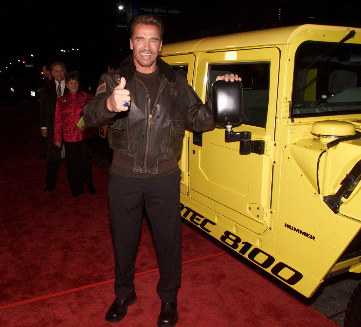 Arnold Schwarzenegger la premiera The 6Th Day, din Los Angeles, anul 2000. A venit îmbrăcat într-o geacă de culoare maro, pantaloni de culoare neagră, și a pozat pe covorul roșu lângă un hummer galben