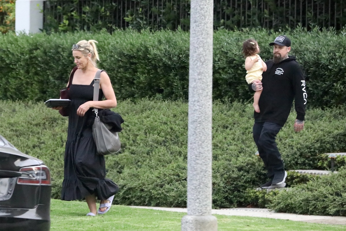 Cameron Diaz, Benji Madden și fiica lor, Raddix Madden, surprinși în Beverly Hills, California, în 2021. Cameron și Benji poartă negru, Raddix e îmbrăcată în alb. Fundal cu verdeață