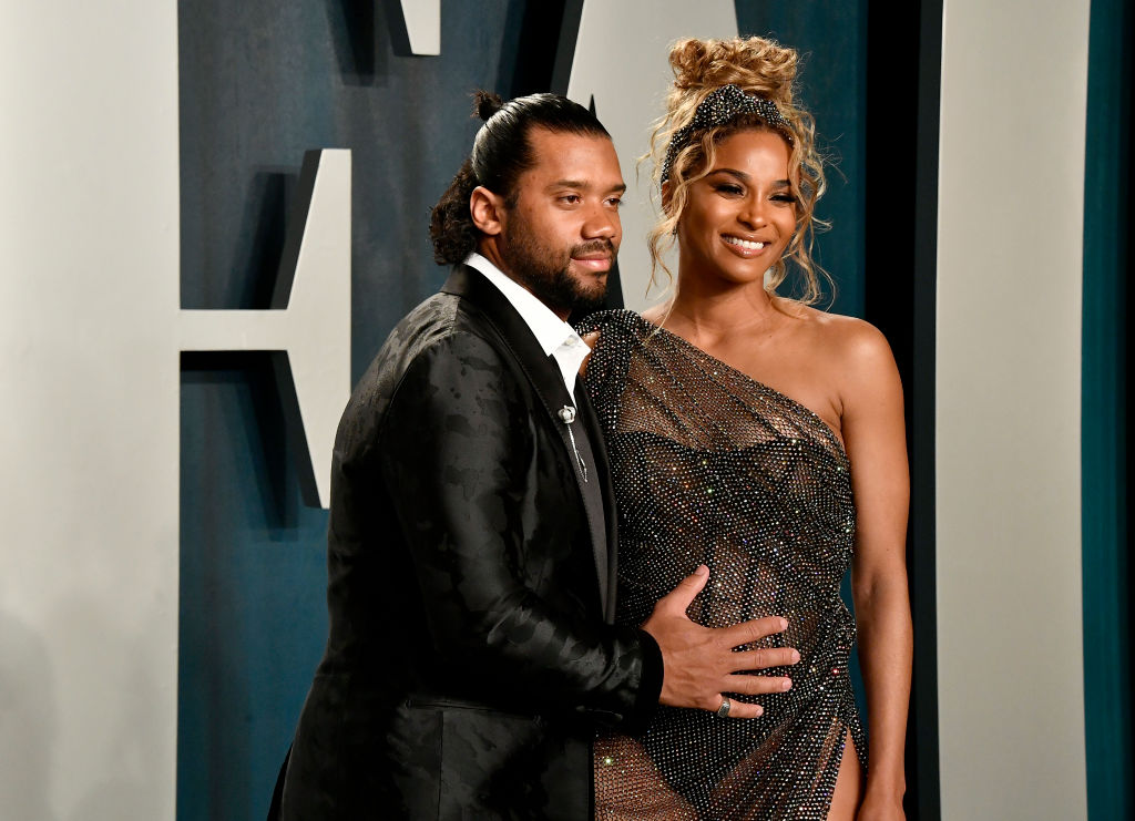 Ciara și Russel Wilson, pe covorul roșu la Vanity Fair Oscar Party, în 2020, în timp ce bărbatul ține mâna pe burtica de gravidă