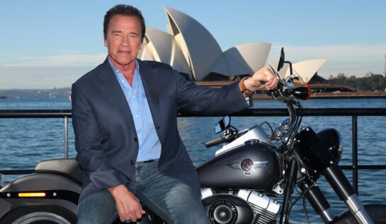 Arnold Schwarzenegger, în 2015, la un eveniment pentru lansarea filmului Terminator: Genisys. A pozat pe o motocicletă, în fata Operei din Sydney. A purtat blugi, o bluză albastră și un blaizer albastru