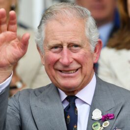 Prințul Charles a aprticipat la Royal Cornwall Show în iunie 2018. A purtat un costum gri, cu o cămașă albă, cu butonieră din flori. Face cu mâna la public, are o mulțime în spate