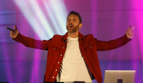 David Guetta, în spectacol în Budapeste, într-o geacă roșie, cu mâinile în aer