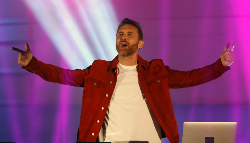 David Guetta, în spectacol în Budapeste, într-o geacă roșie, cu mâinile în aer
