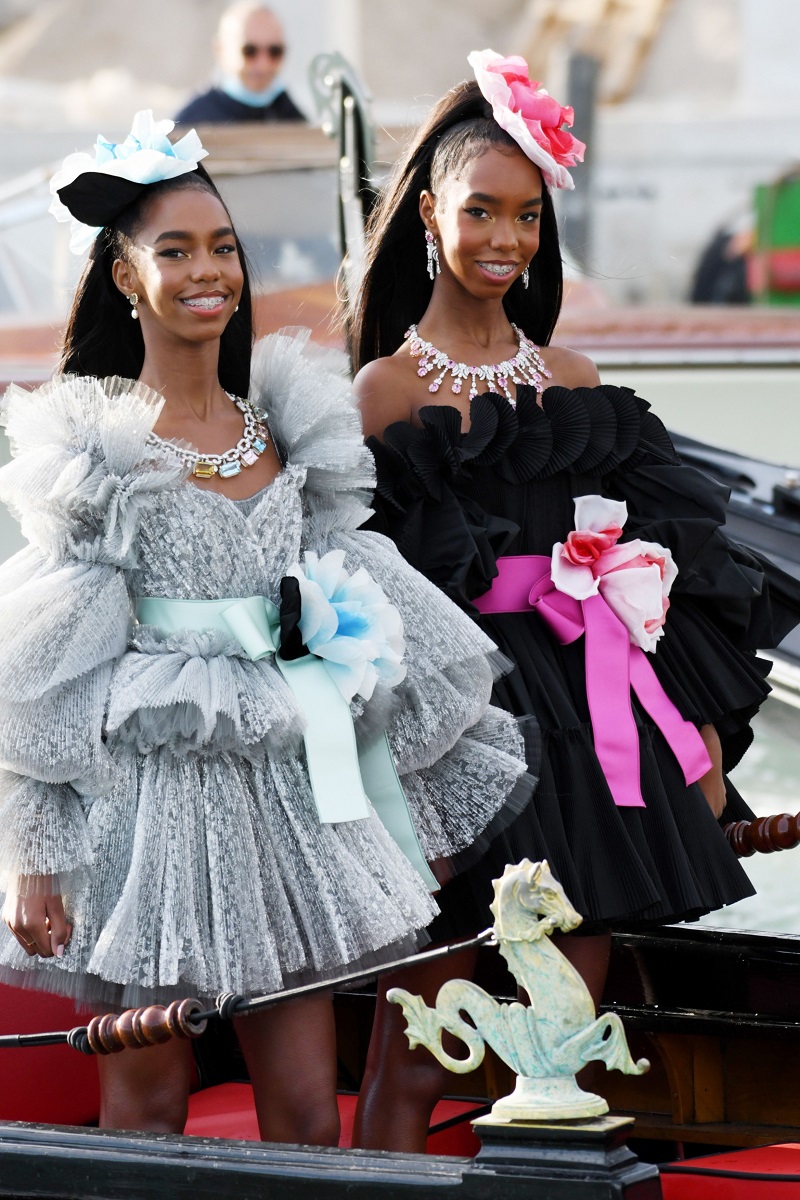 D'Lila Star și Jessie James Combs, fiicele lui P. Diddy, la prezentarea de modă Dolce & Gabbana Alto Moda, din Veneția, august 2021. Una poartă p rpchie neagră, cealaltă o rochie argintie. Sunt în gondolă și au un accesoriu în păr