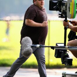 Jonah Hill surprins pe platoul de filmare al Get Him To The Greek, în timpul filmărilor. Actorul alerga în blugi și tricou, cu fundal gri cu galben