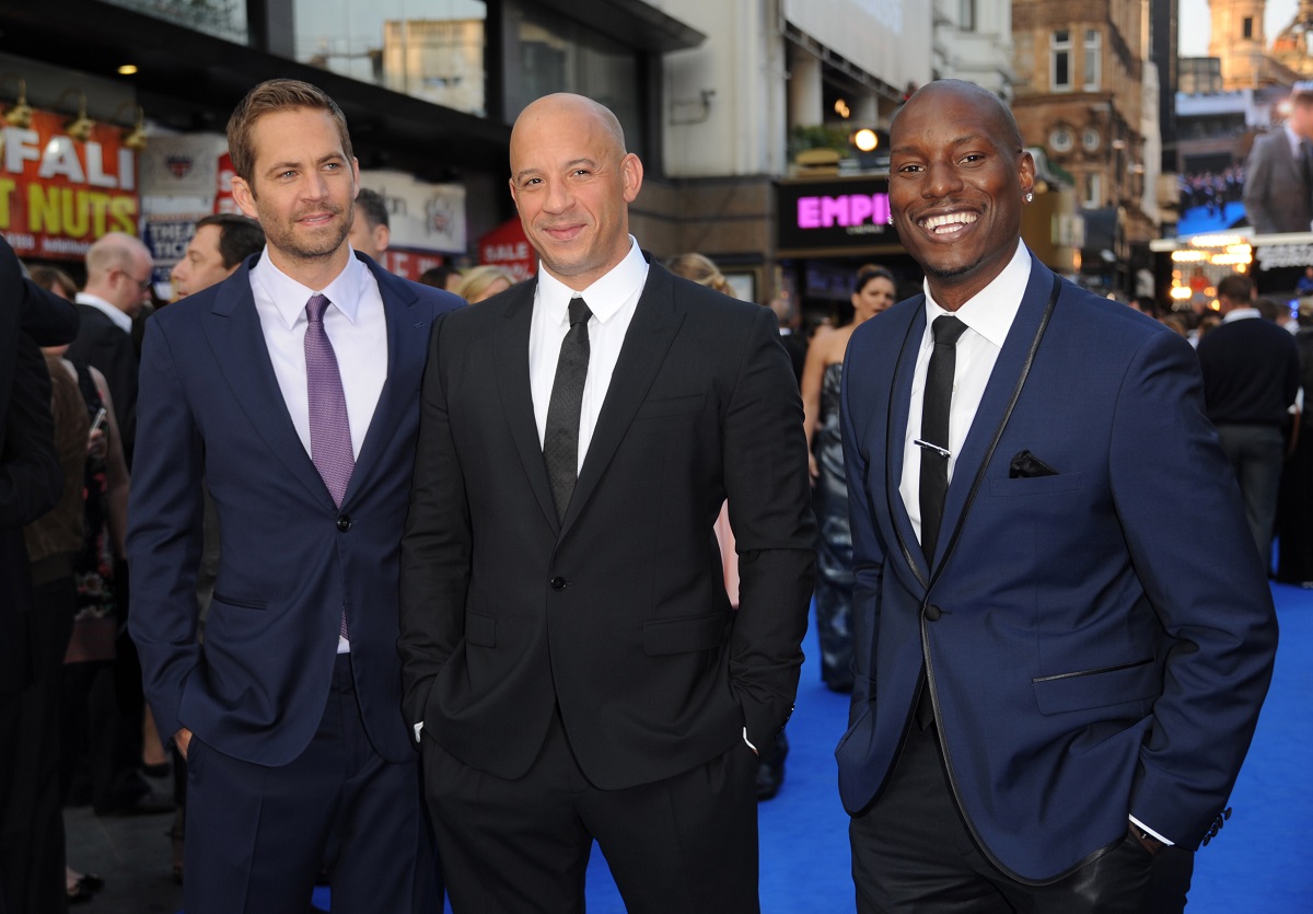Paul Walker, Vin Diesel, Tyrese Gibson, la premiera Fast and Furious 6, din Londta, Anglia, în mai 2013. Toți au purtat costume ănchise la culoare și bluze deschise la culoare. Fundal cu albastru