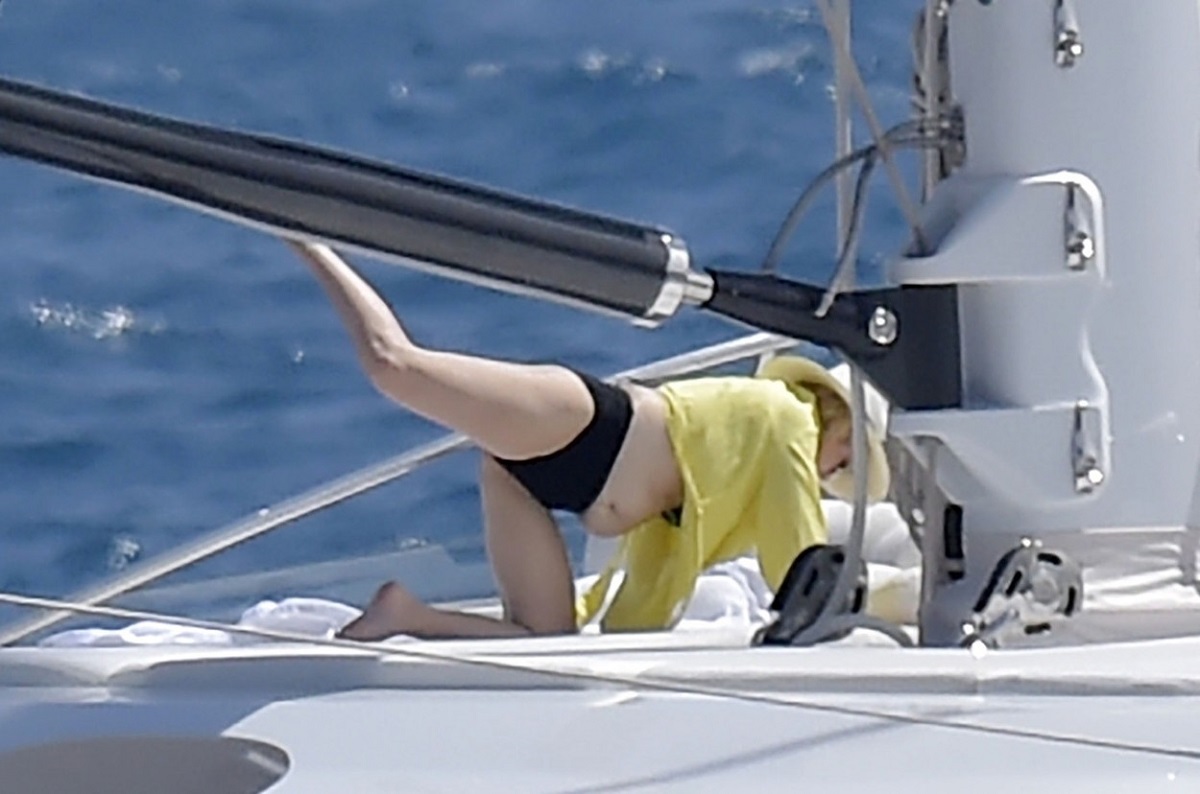 Rebel Wilson s-a relaxat pe un iaht luxos în Portofino, Italia. Ea a purtat un costum de baie negru și o rochie galbenă. Iahtul e alb, pe fundal se vede marea