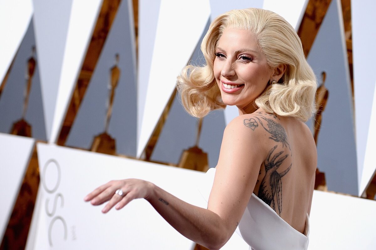 Lady Gaga a apărut la cea de-a 88-a ediție a Premiilor Oscar într-o rochie albă, fără mâneci, ce i-a pus în evidență tatuajele. Ea a purtat părul blond în bucle ușoare, cu fundal cu alb și gri