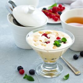 Zabaglione servit în cupă de înghețată, alături de o ceașcă cu ceai și fructe