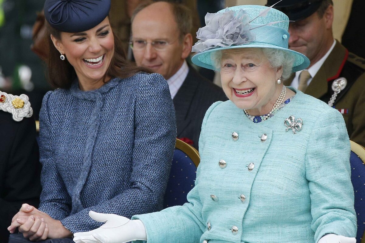 Regina Elisabeta și Kate Middleton, Ducesa de Cambridge, în 2012, în Nottingham. Regina poartă un costum albastru deschis, Kate un costum albastru închis