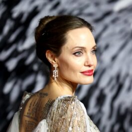 Actrița Angelina Jolie cu părul prins într-un coc pe covorul roșu la premiera filmului Maleficent
