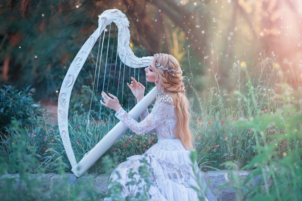 O femeie frumoasă care poartă o rochie albă și se folosește de talentul său ascuns pentru a cânta la harpă