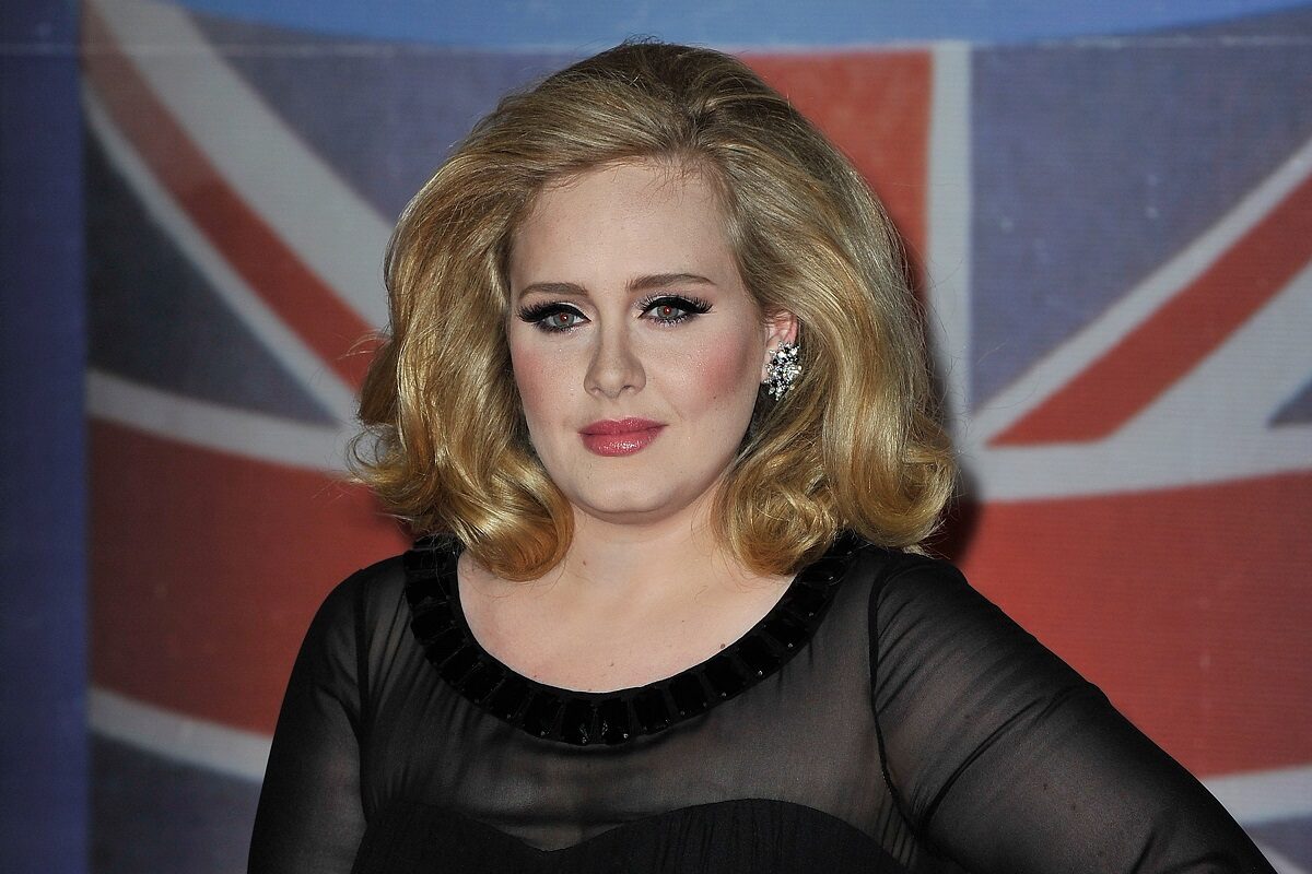 Portret al vedetei Adele care paortă o bluză neagră cu mâneci transparente în timp ce pozează la the brit awards 2012