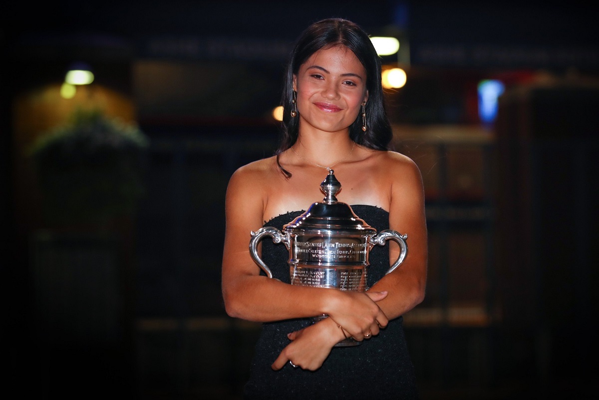 Emma Răducanu într-o rochie neagră, cu trofeul US Open 2021 în brațe