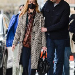 Jennifer Lawrence într-un palton lung în carouri cu mască pe față în timp ce merge alături de soțul său Cooke Maroney pe străzile din New York