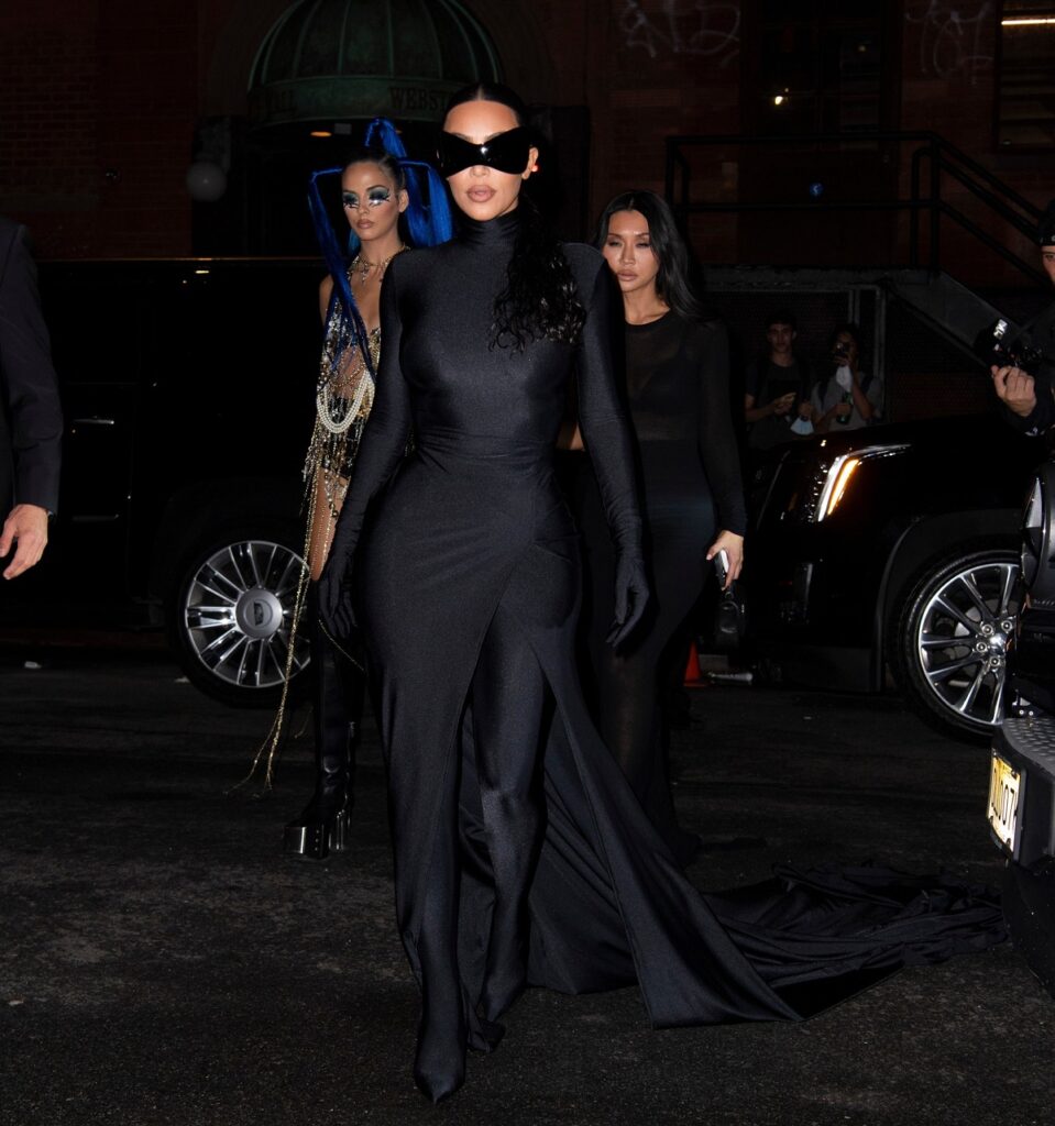 Kim Kardashian îmbrăcată într-un costum negru mulat cu trenă în timp ce merge la petrecerea după Met Gala 2021