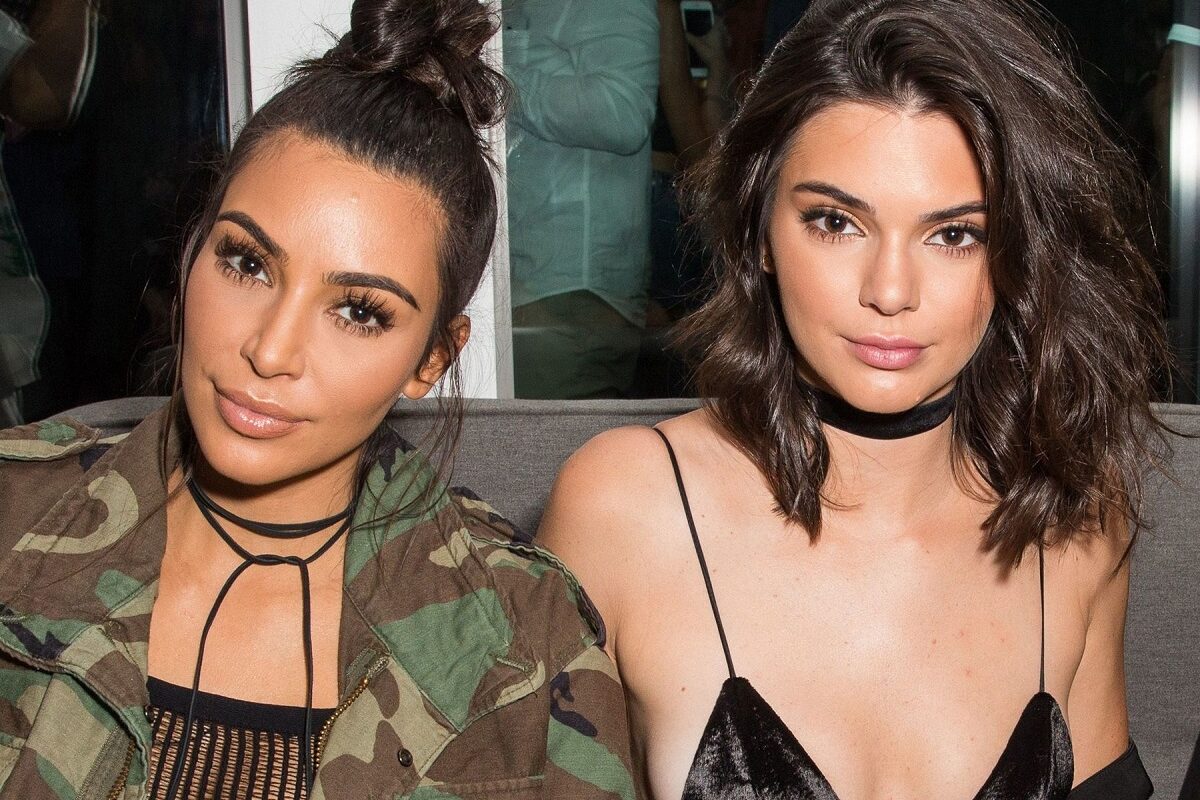 Kim Kardashian și Kendall Jenner în timp ce pozează la un eveniment din 2018 împreună