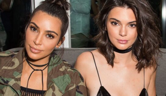 Kim Kardashian și Kendall Jenner în timp ce pozează la un eveniment din 2018 împreună