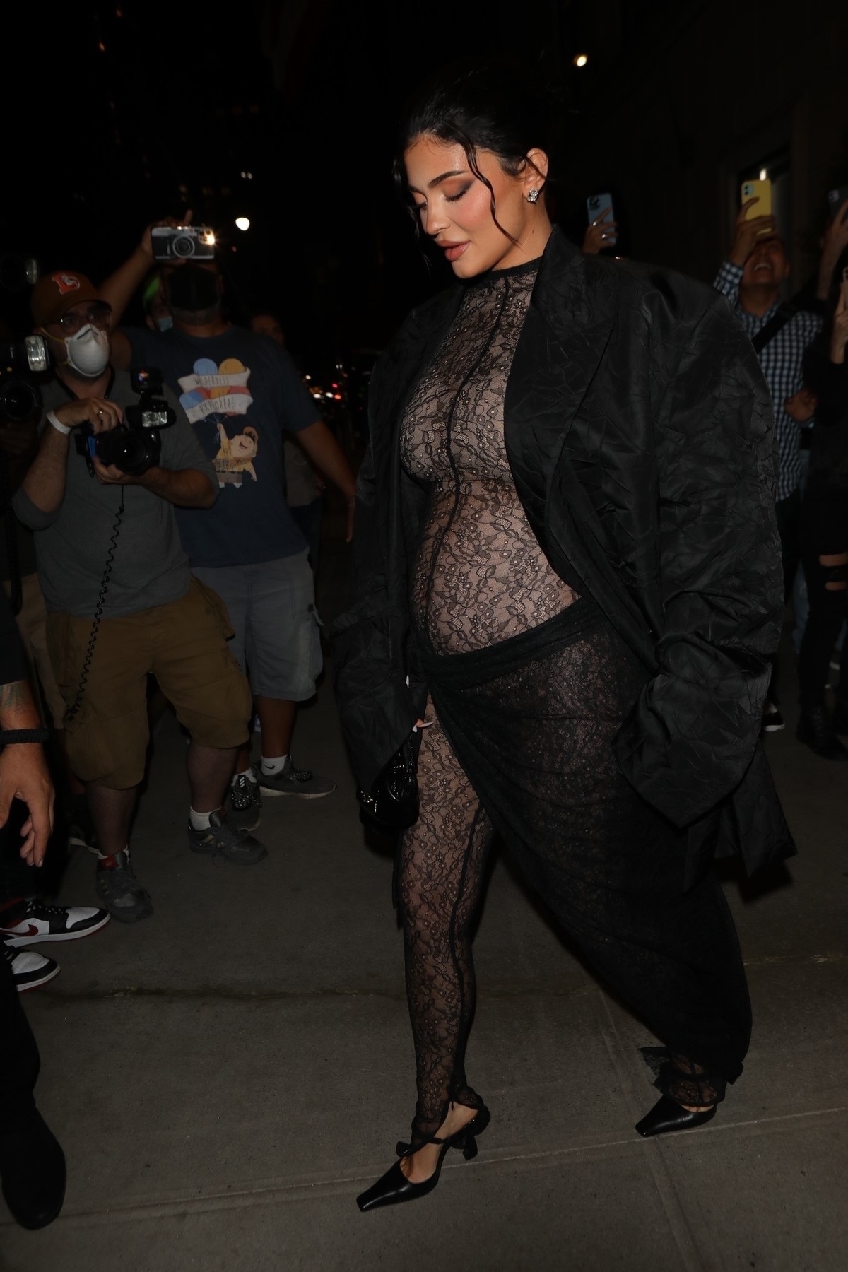 Kylie Jenner părăsind un hotel din New York în timp ce poartă un costum transparent din dantelă neagră și un sacou negru care să o acopere