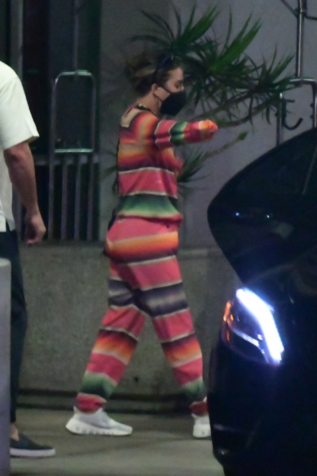 Lady Gaga într-un costum de trening în dungi colorate cu roz și verde în timp ce părăsește aeroportul din Los Angeles