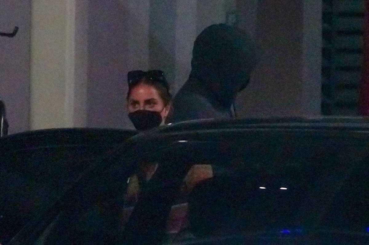 Lady Gaga cu mască neagră pe față în timp ce stă după p mașină neagră în aeroportul din Los Angeles