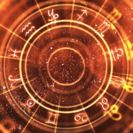O imagine cu harta astrală și cu zodiile așezate în cerc pe un fundal roșu penru a simboliza evenimentul lui mercur retrograd din luna septembrie
