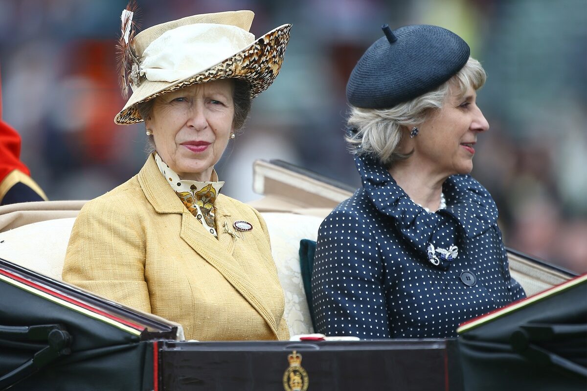 Prințesa Anne și Ducesa de Gloucester în trăsură. Anne proată o haină galbenă și o pălărie în aceeași nuanță. Ducesa de Gloucester poartă albastru