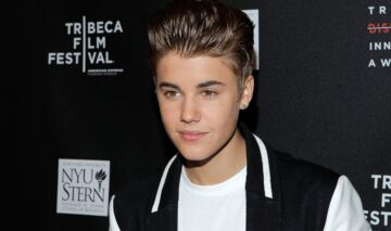 Portretul artistului Justin Bieber care poartă o bluză albă și o vestă neagră la Festivalul de Film de la Tribeca din 2012