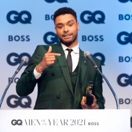 Regé-Jean Page purtând un costum verde smarald în timp ce ține un discurs după ce a primit un premiu pentru activitatea sa din ultimul an la festivitatea British GQ Men of the Year Awards 2021