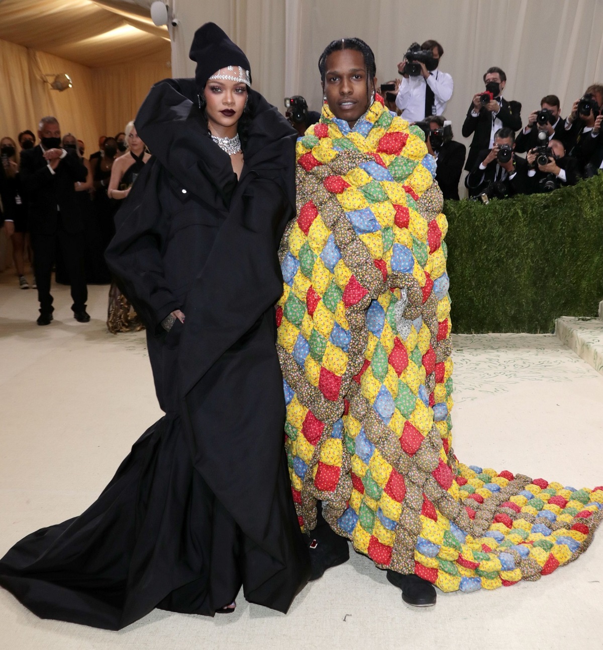 Rihanna și A$AP Rocky pe covorul roșu la Met Gala 2021 în timp ce poartă o rochie neagră, iar Asap poartă o pătură colorată