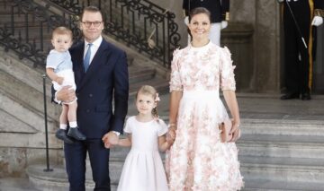 Prințesa Victoria, prințul Daniel, Prințesa Estelle și Prințul Oscar ai Suediei în 2017, când Victoria a ămolinit 40 de ani. Fetele poartă roz, Daniel poartă un costum închis la culoare, fundal cu scari