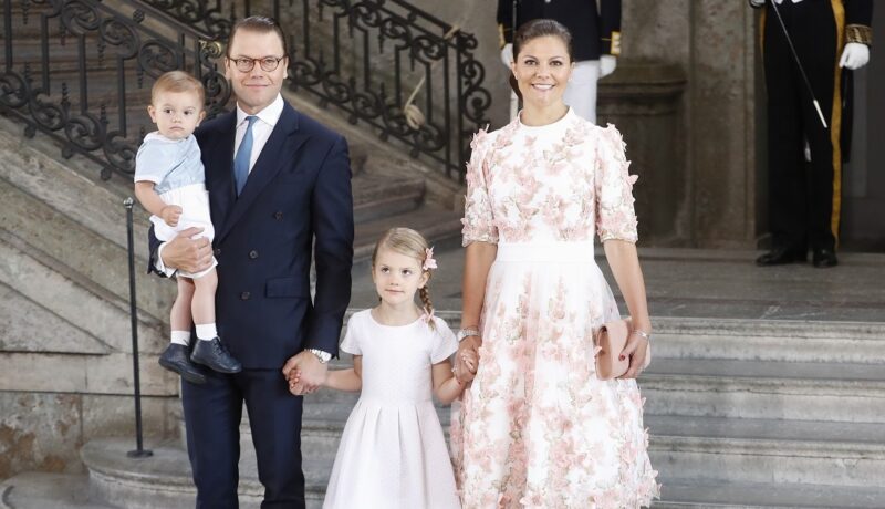 Prințesa Victoria, prințul Daniel, Prințesa Estelle și Prințul Oscar ai Suediei în 2017, când Victoria a ămolinit 40 de ani. Fetele poartă roz, Daniel poartă un costum închis la culoare, fundal cu scari