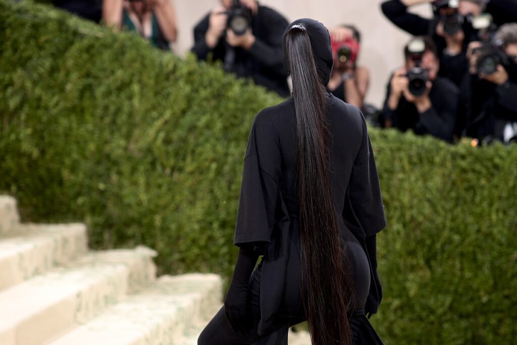 Părul lui Kim Kardashian la Met Gala 2021 în timp ce urcă pe scări și poartă o ținută neagră