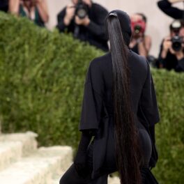 Părul lui Kim Kardashian la Met Gala 2021 în timp ce urcă pe scări și poartă o ținută neagră