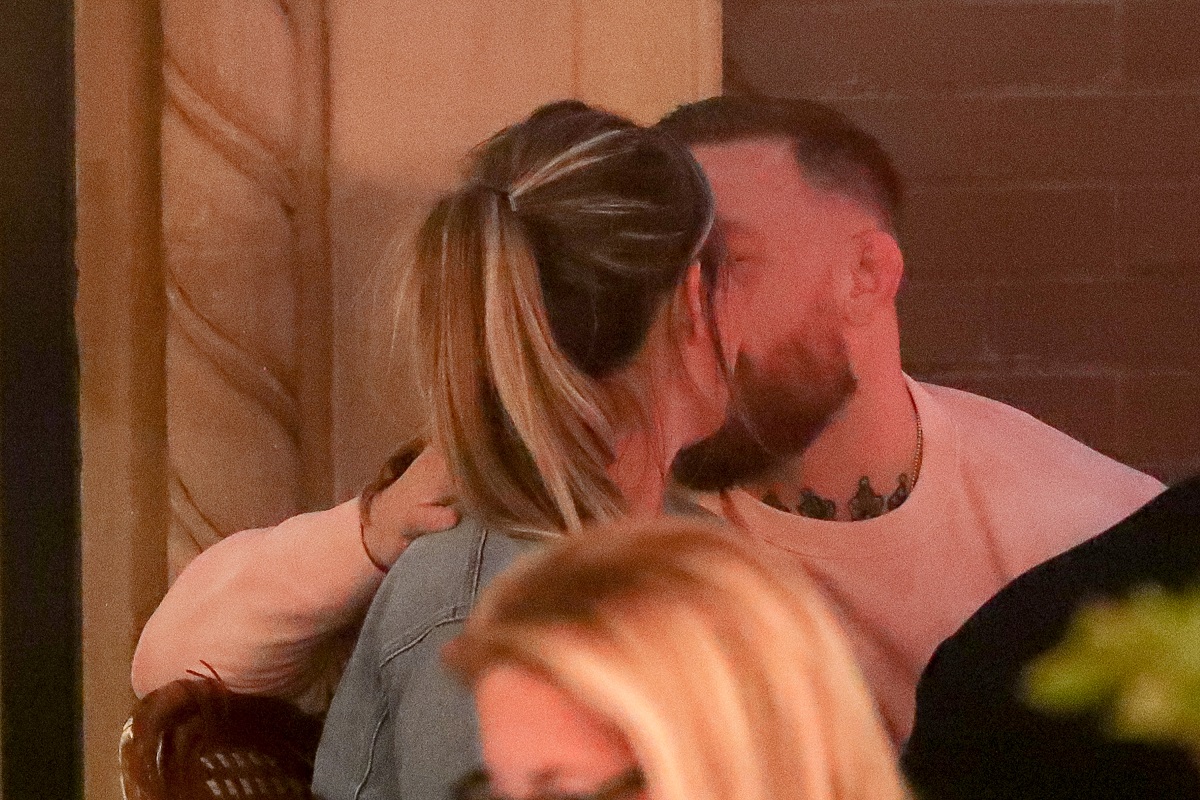 Conor McGregor și Dee Devlin la un restaurant în New York, se sărută. El poartă o bluză albă, ea o haină de blugi