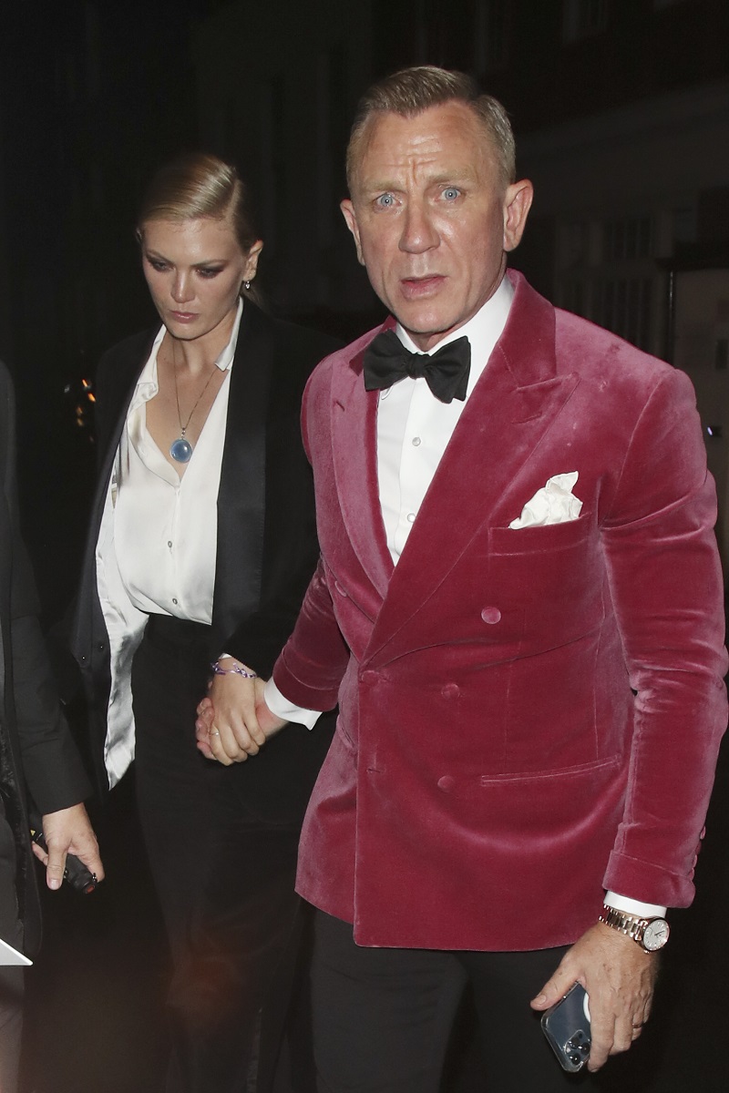 Daniel Craig și Ella Loudon după premiera No Time To Die, din Londra. El poartă jachetă roz, ea poartă o bluză albă și costum negru
