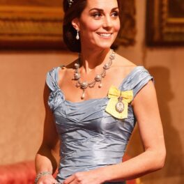 Kate Middleton, în timpul vizitei de stat a familiei regale din Țările de Jos. A purtat tiara Cambridge și o rochie albastră. Fundal cu lemn portocaliu