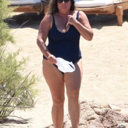 Kelly Brosnan, la plajă, într-un costum de baie negru, întreg
