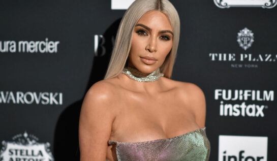 Kim Kardashian, într-o rochie argintie, pe covorul roșu la un eveniment Harper's BAZAAR