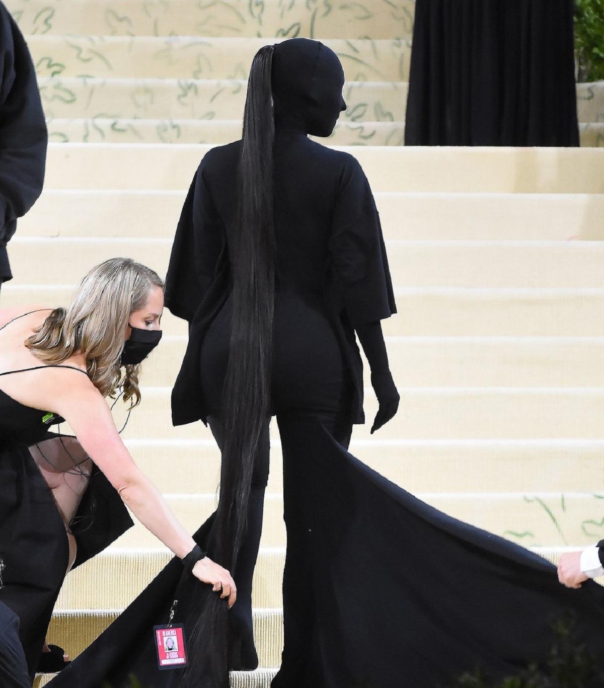 Kim Kardashian în timp ce stă cu spatele pe scările de la Met Gala 2021 și pozează