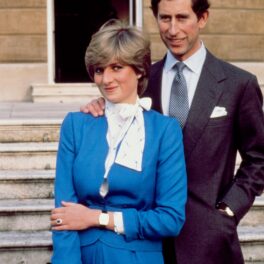 Prințul Charles și Prințesa Diana în ziua anunțului logodnei lor. Diana a purtat o rochie albastră cu accente albe și o geantă neagră. Charles a purtat un costum închis la culoare, bluză deschisă și o cravată albastră
