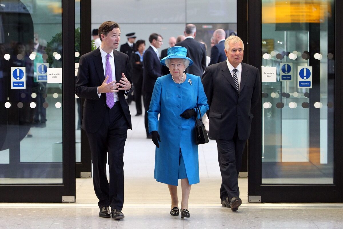 Regina Elisabeta revine în Marea Britanie în anul2 014, în aeroportul Heathrow, Londra. E îmbrăcată într-un costum albastru