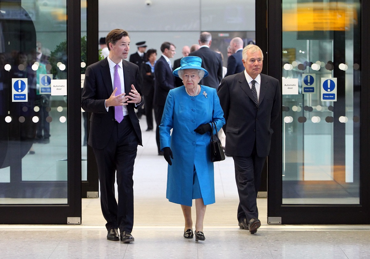Regina Elisabeta revine în Marea Britanie în anul2 014, în aeroportul Heathrow, Londra. E îmbrăcată într-un costum albastru