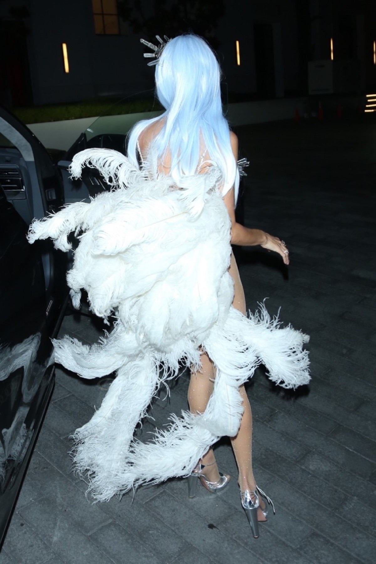 Alessandra Ambrosio cu spatele pe care are pene albe în timp ce vine la o petrecere de Halloween