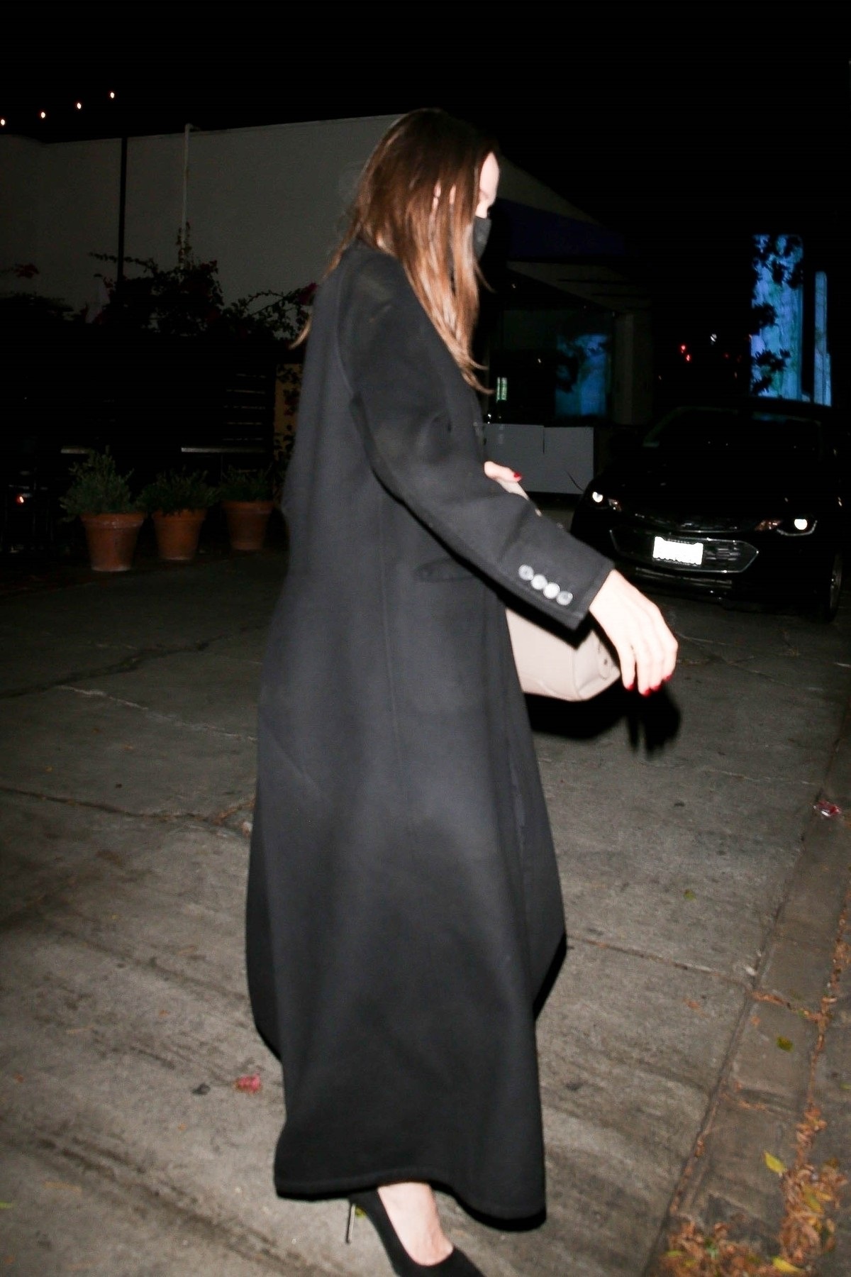 Angelina Jolie într-un palton lung negru după ce a luat cina cu Jonny Lee Miller