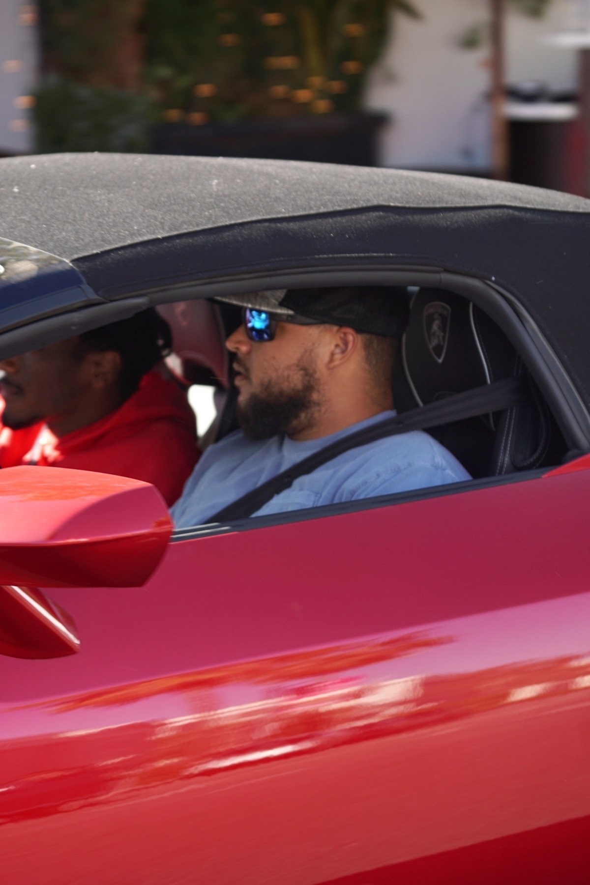 Connor Cruise la volanul unei mașini roși pe străzile din Los Angeles