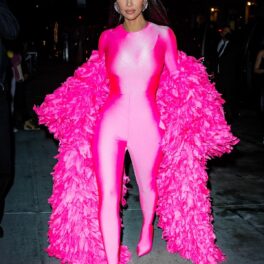 Kim Kardashian înr-un costum mulat roz peste care a purtat un palton roz cu pene în timp ce se îndrepta la o petrecere din New York