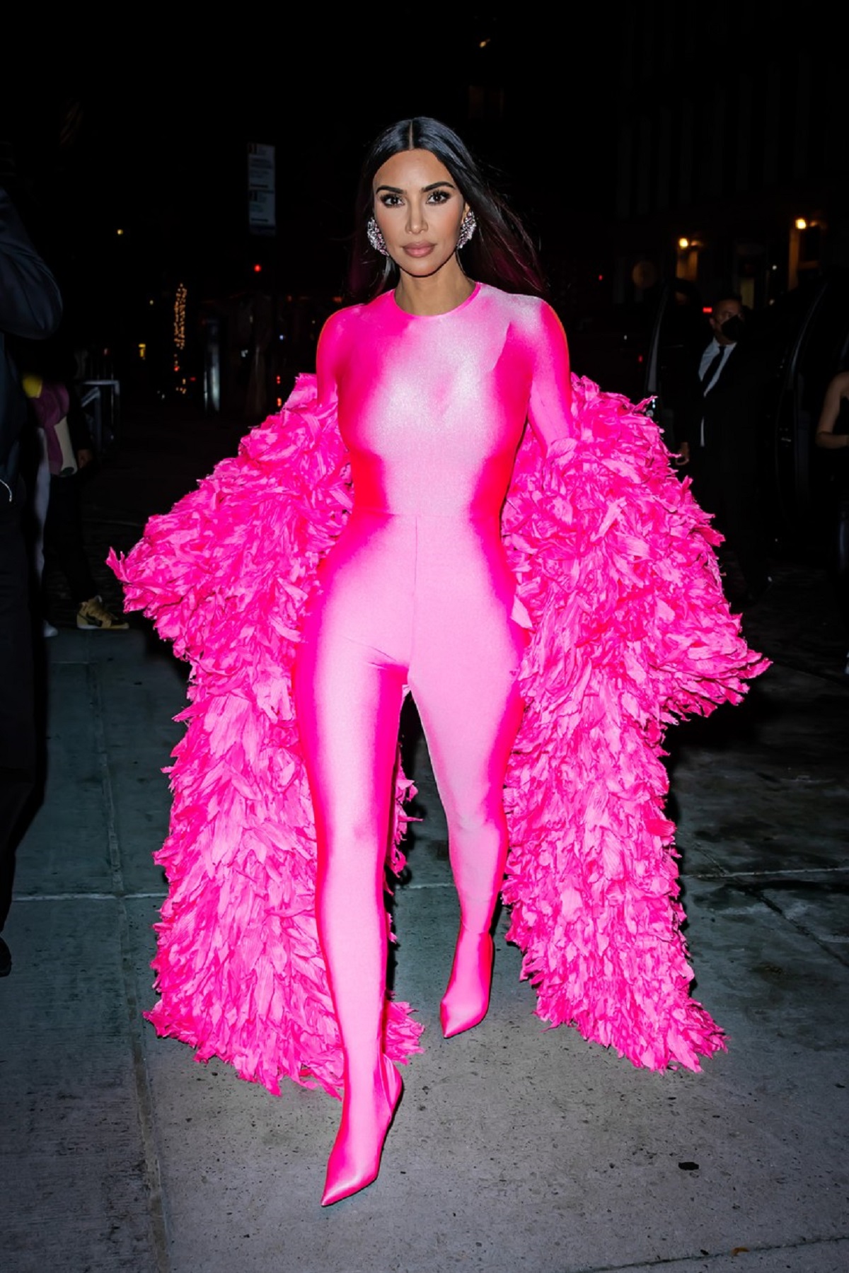 Kim Kardashian înr-un costum mulat roz peste care a purtat un palton roz cu pene în timp ce se îndrepta la o petrecere din New York