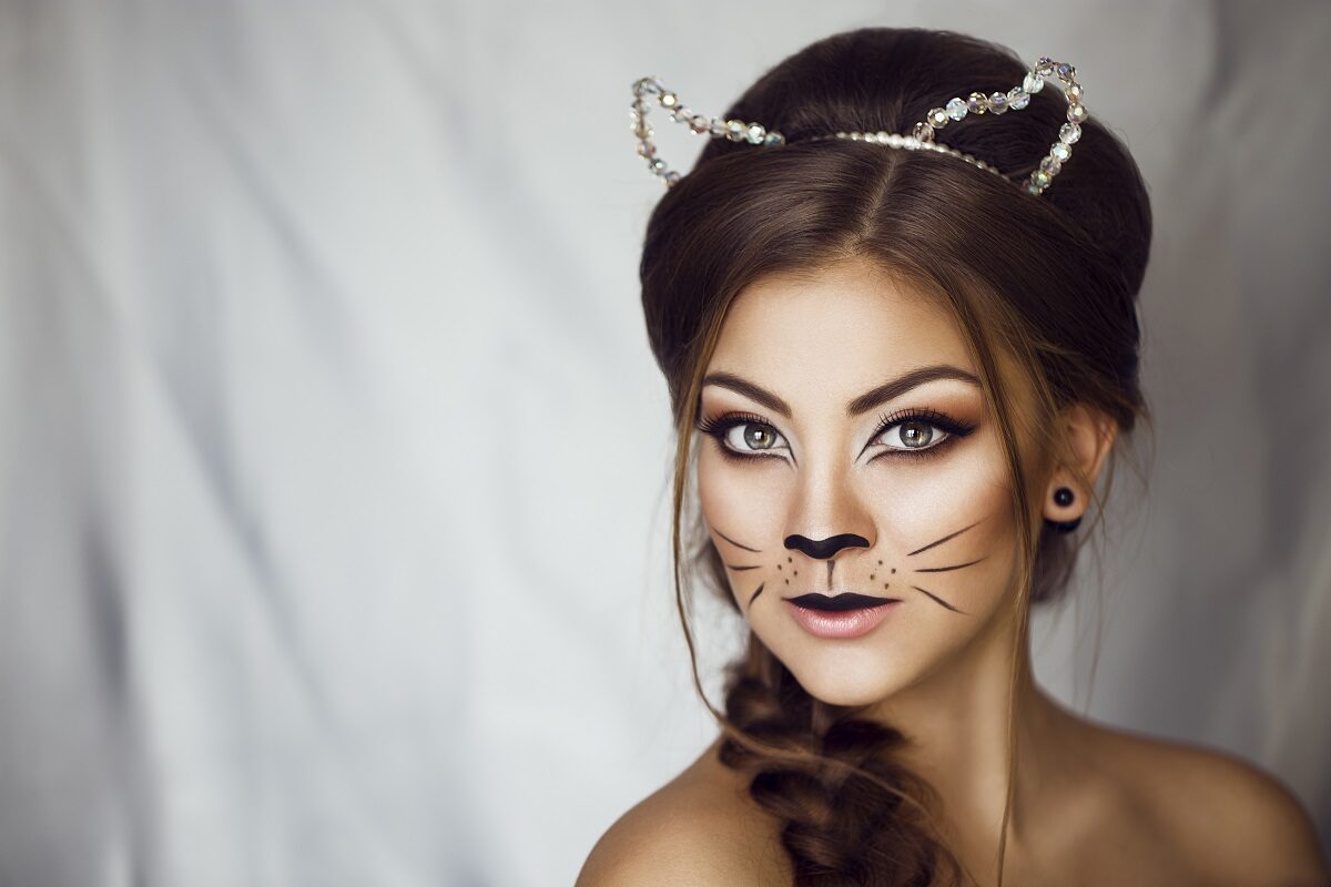 O femeie frumoasă cu un look de felină după ce a aplicat unul din acele machiaje de Halloween